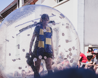 Photo d'une comédienne à l'intérieur d'un gros ballon transparent durant le spectacle
