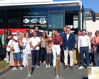 Vue des nouveaux habitants de la commune et d'élus devant le car lors de leur accueil en septembre 2025
