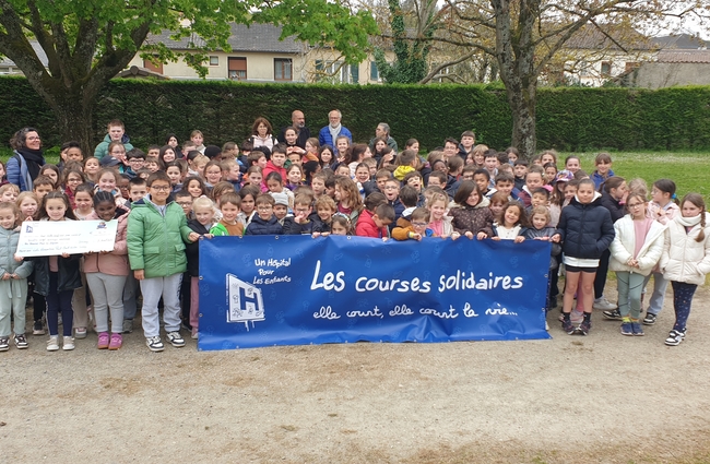 Le groupe d'élèves ayant participé la course solidaire tenant une banderole de l'association Un hôpital pour les enfants et le fac-similé du chèque