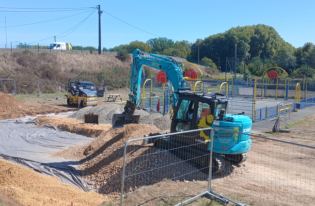 Vue de deux engins de travaux publics qui réalisent le terrassement du futur terrain de basket 3X3