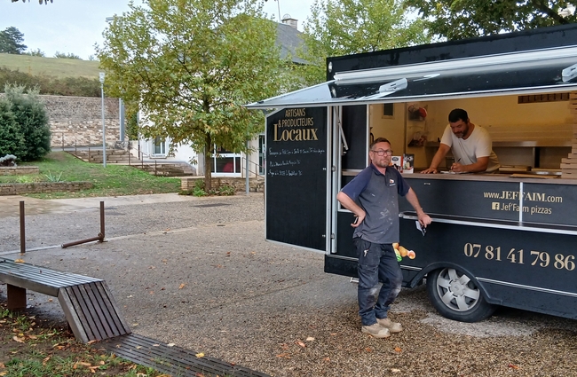 Vue du camion de vente de pizza avec le commerçant à l'intérieur et un client devant