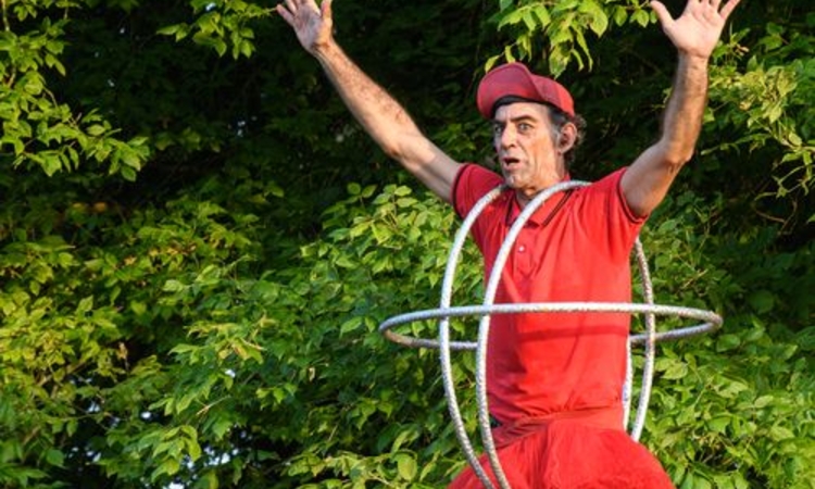 Image de l'artiste sur un ballon avec des cerceaux autour du corps