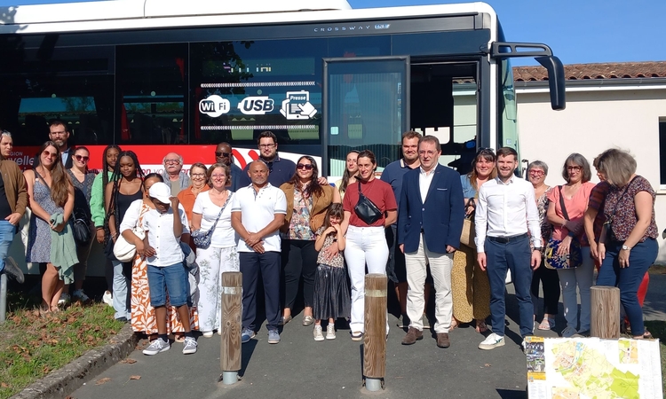 Vue des nouveaux habitants de la commune et d'élus devant le car lors de leur accueil en septembre 2025