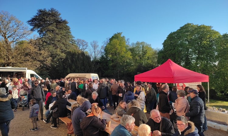 Vue d'un marché de producteurs avec le public attablé devant les stands