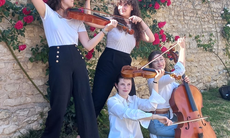 Vue des 4 musiciennes le long d'un mur dans un parc avec leurs instruments