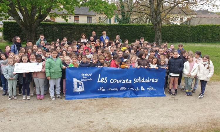 Le groupe d'élèves ayant participé la course solidaire tenant une banderole de l'association Un hôpital pour les enfants et le fac-similé du chèque